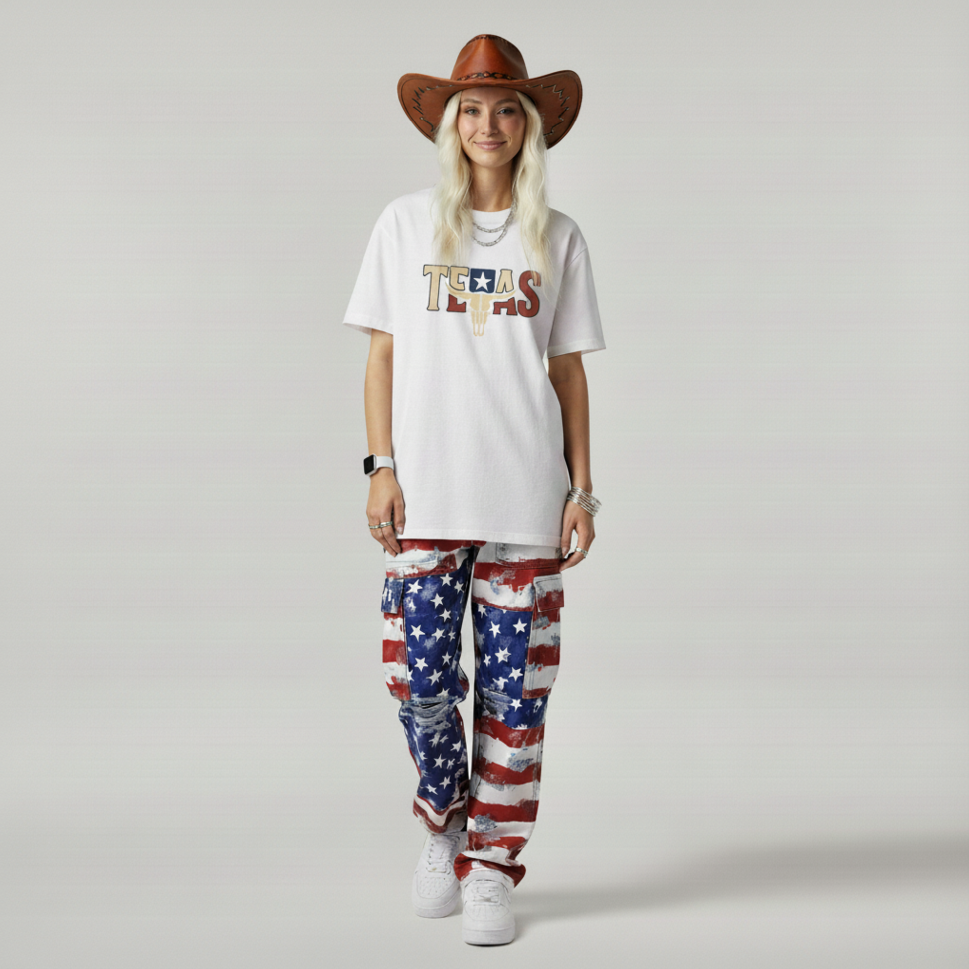 Person wearing a white 'TEXAS' t-shirt and American flag pants with a cowboy hat on a plain background